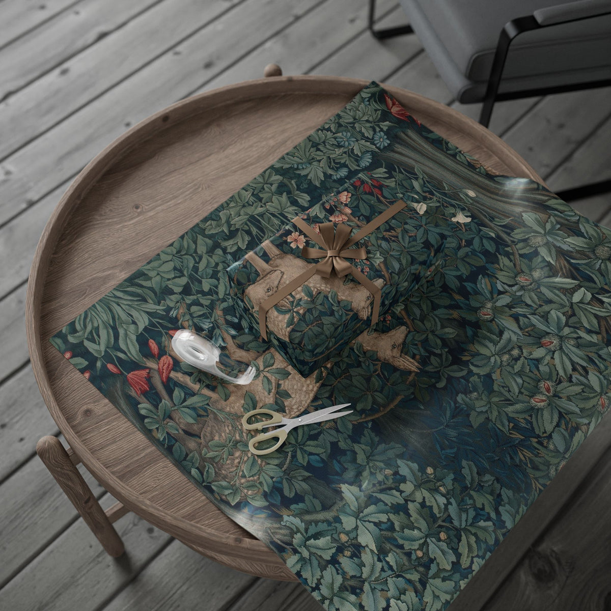 Wooden tray with a green floral-patterned wrapping paper, sewing items, and a chair in the background.
