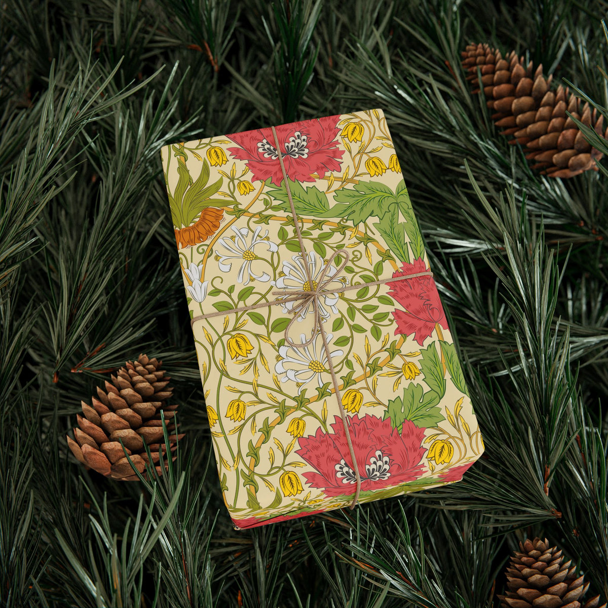 Floral notebook on a green leafy background with pine cones