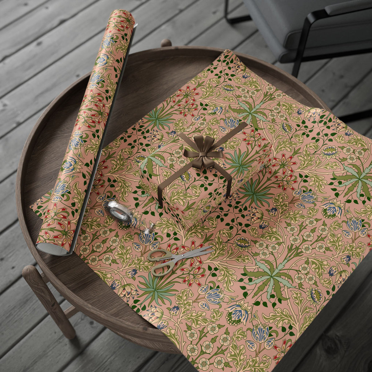 Floral-patterned gift wrap on a wooden tray with scissors on a wooden surface.