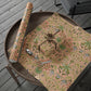 Floral-patterned gift wrap on a wooden tray with scissors on a wooden surface.