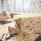 Gift wrapped in floral patterned paper with a ribbon on a table.