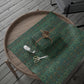 Green patterned wrapping paper with a gift box and scissors on a wooden surface