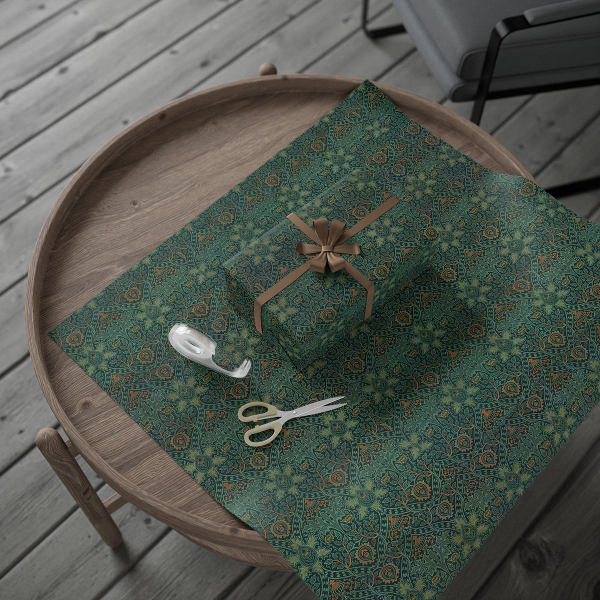 Green patterned wrapping paper with a gift box and scissors on a wooden surface