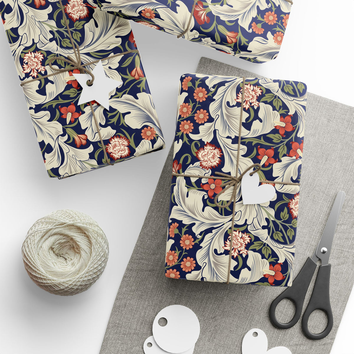 Floral-patterned packages with string, scissors, and yarn on a white surface