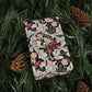 Floral-patterned notebook on green leaves with pine cones