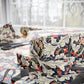 Floral-patterned fabric on a bed with scissors in the background