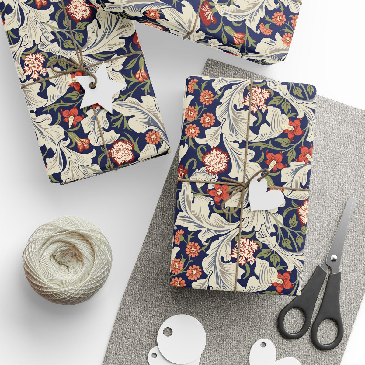 Floral-patterned packages with string, scissors, and yarn on a white surface