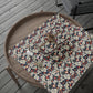 Floral-patterned wrapping paper on a wooden tray with a wooden chair in the background.