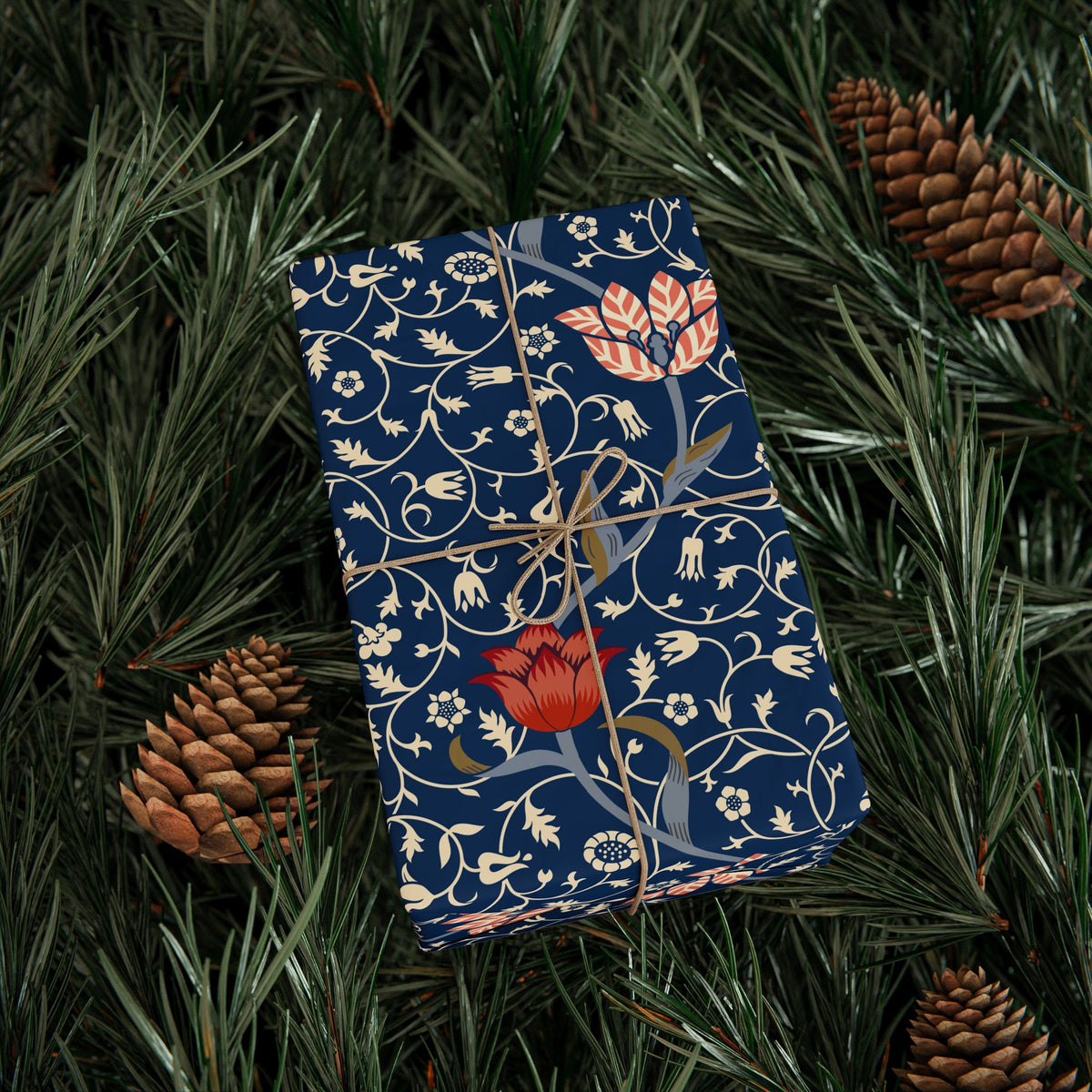 Decorative box with floral pattern on a bed of pine needles and pine cones