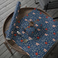 Decorative blue fabric with floral pattern on a wooden surface