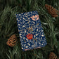 Gift wrapped in blue floral paper with pine cones and greenery