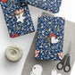 Gift wrap with floral pattern, scissors, twine, and tags on a white surface