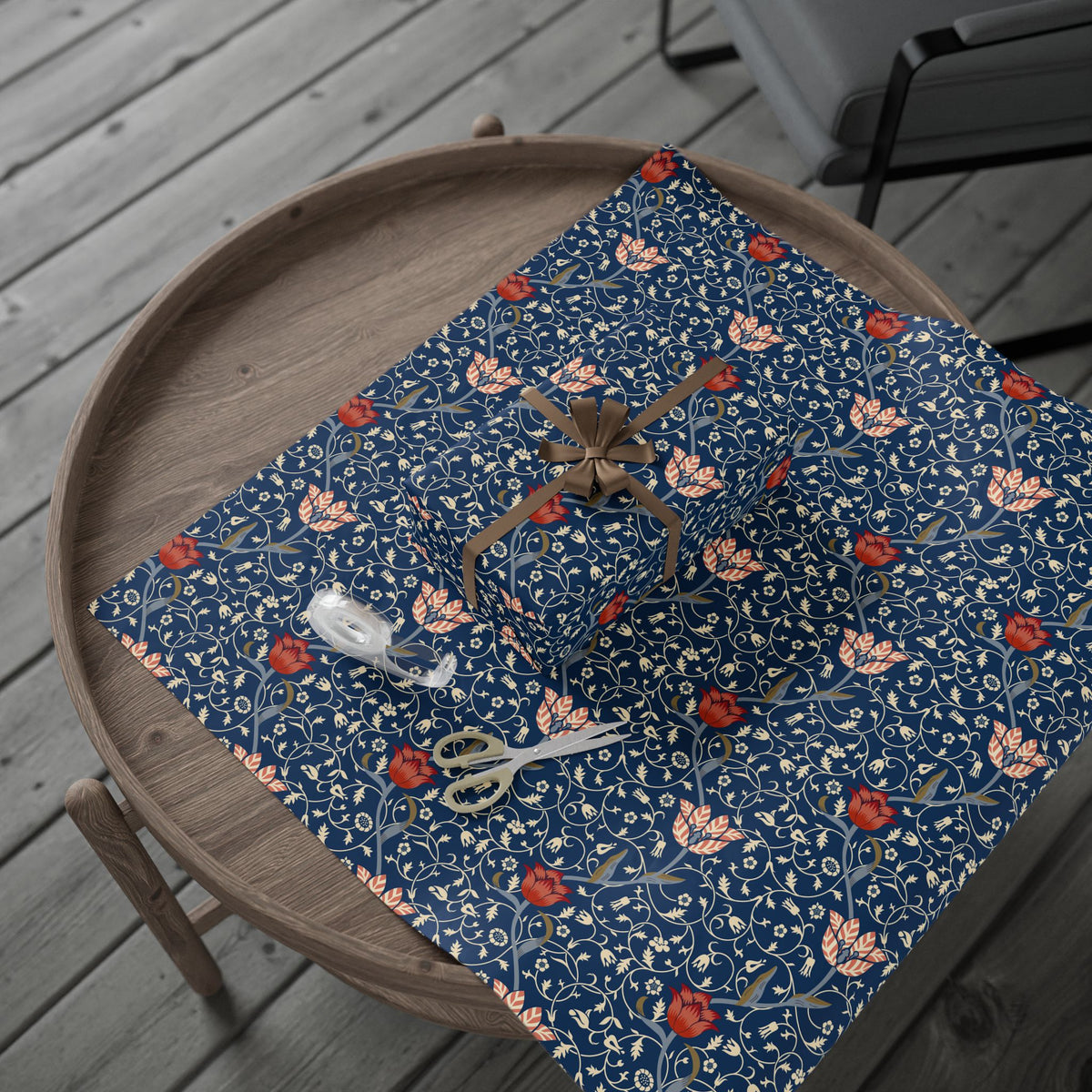 Decorative blue floral placemat on a wooden table with a spider and scissors.
