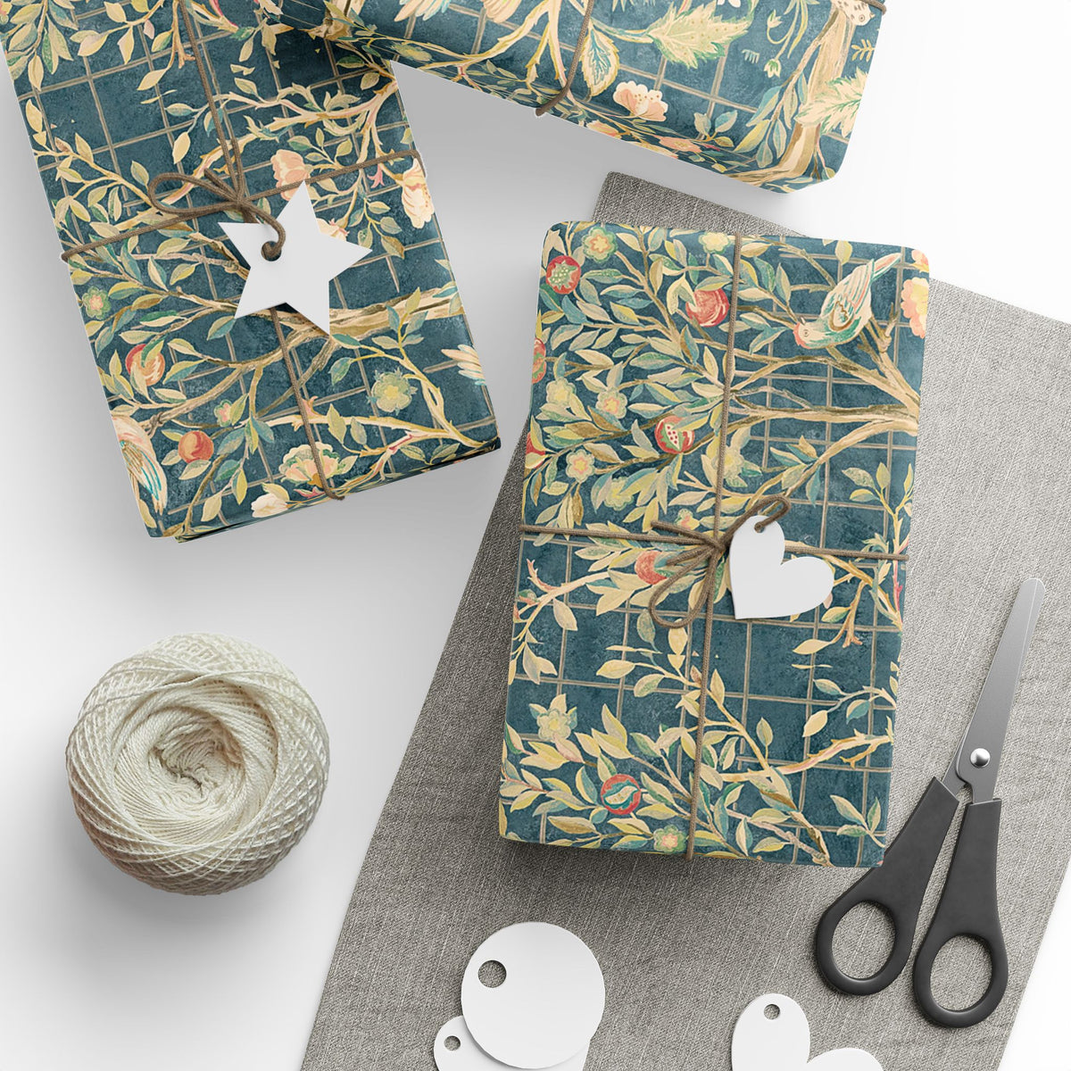 Gift-wrapped packages with decorative paper, scissors, and yarn on a white surface