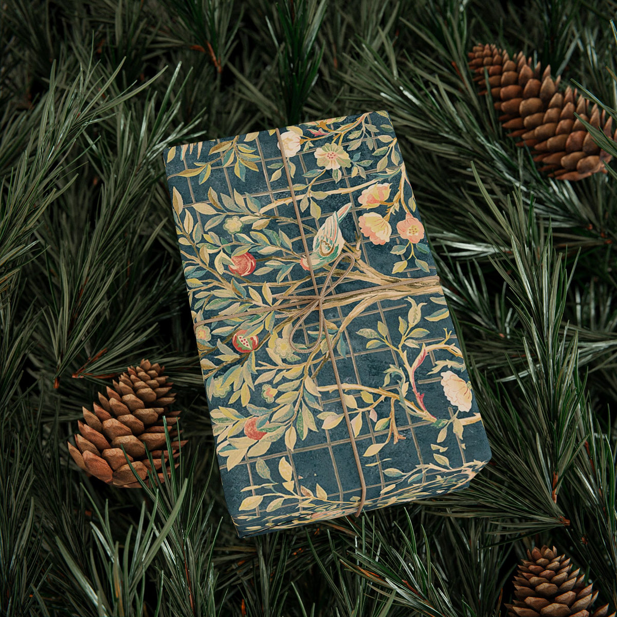 Decorative box with nature-themed design on a bed of pine needles and pine cones