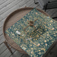 Decorative teal cloth with floral patterns on a wooden tray
