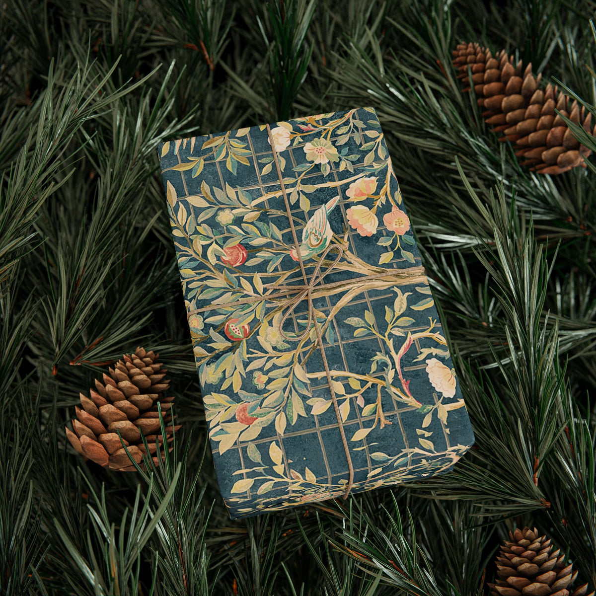 Decorative box with nature-themed design on a bed of pine needles and pine cones