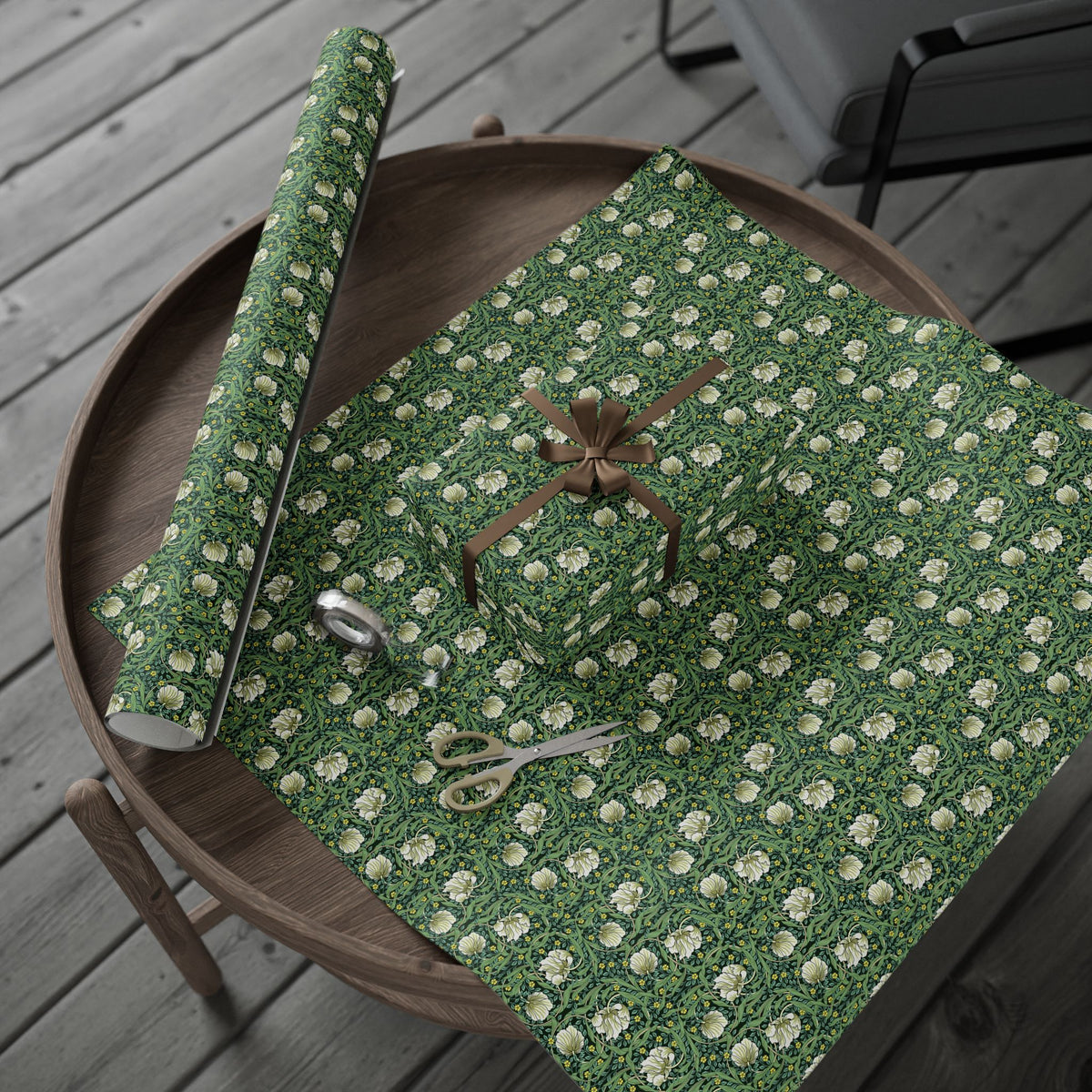 Green floral-patterned fabric with a pair of scissors on a wooden surface