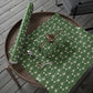 Green floral-patterned paper with scissors on a wooden tray