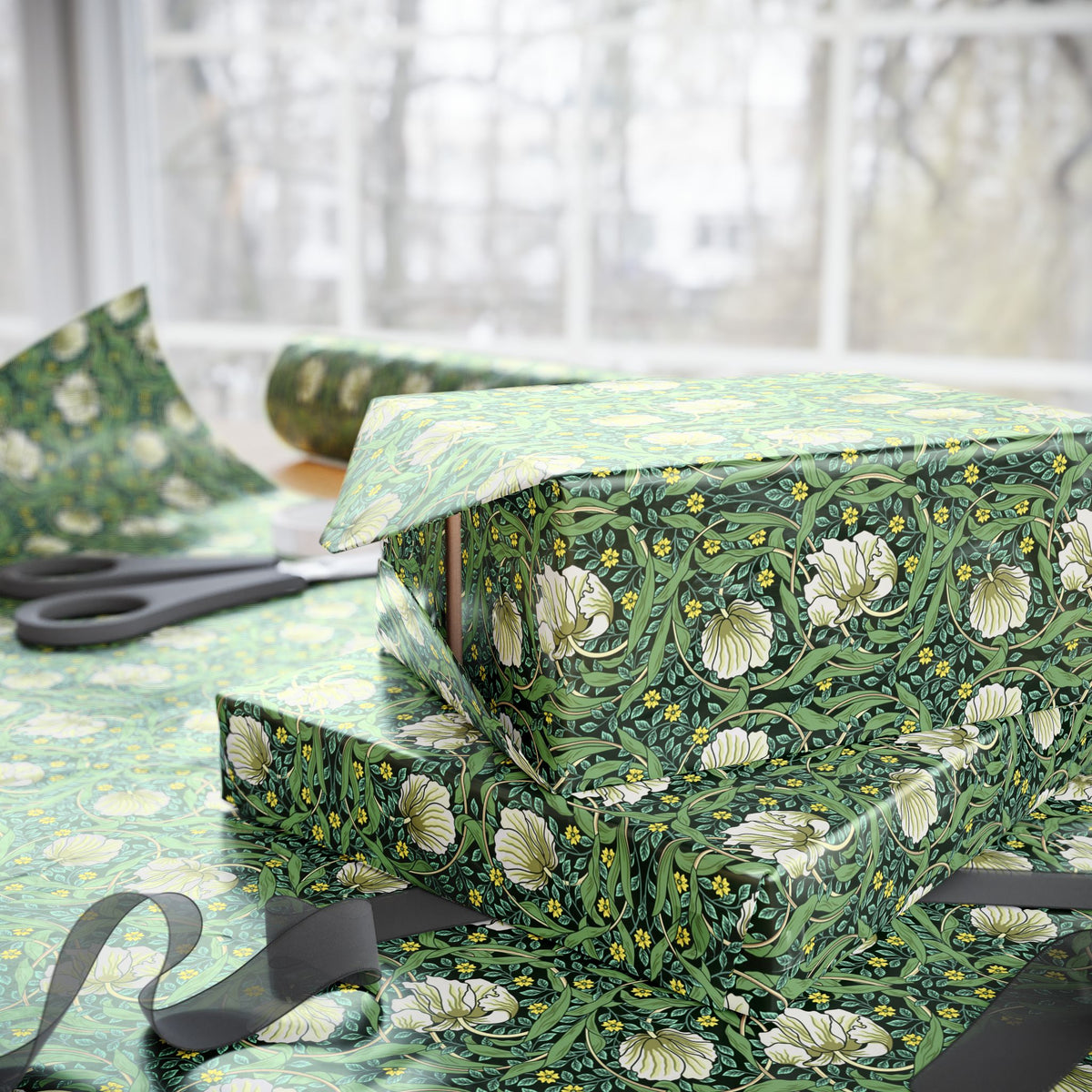 Green floral-patterned box with ribbon on a matching fabric background