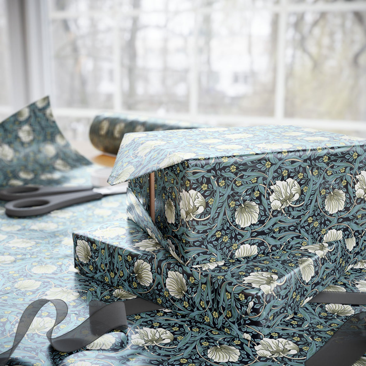 Gift wrapped in blue floral paper with scissors on a table