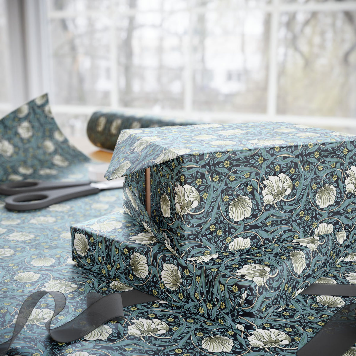 Gift wrapped in blue floral paper with ribbons on a table.