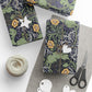 Gift-wrapped packages with decorative paper, scissors, and yarn on a white surface