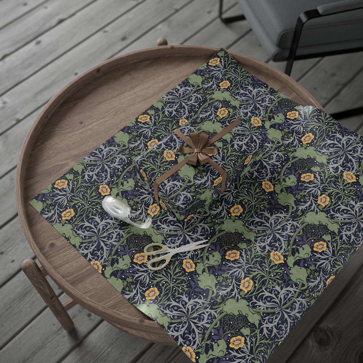Floral-patterned wrapping paper on a wooden tray with scissors on a wooden surface