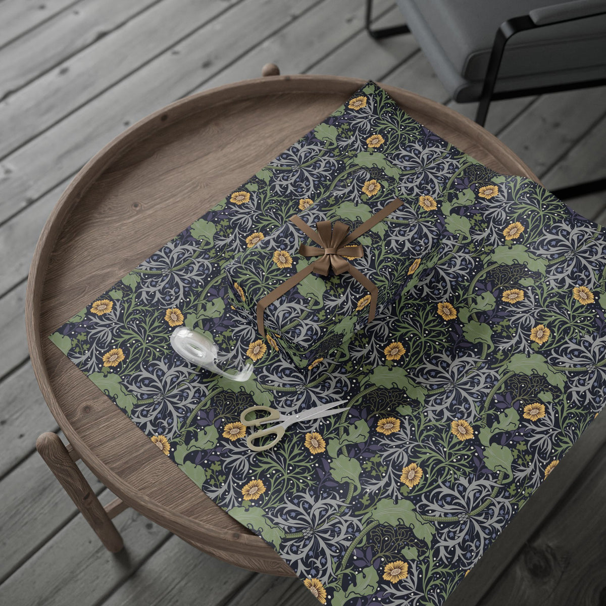 Floral-patterned wrapping paper with scissors on a wooden tray outdoors.