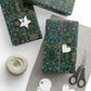 Gifts wrapped in green floral paper with decorative tags and scissors on a white surface