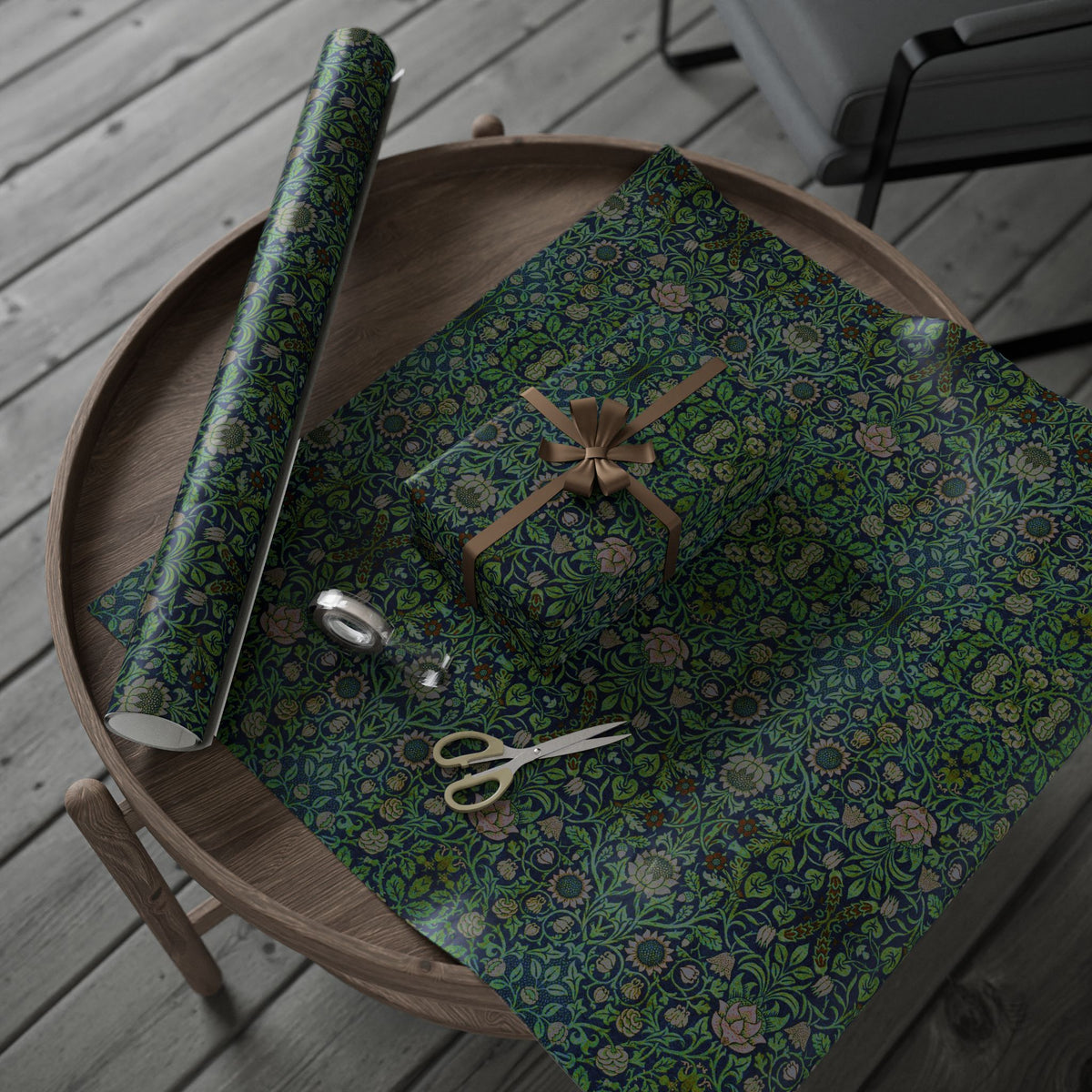 Roll of green floral-patterned paper on a wooden tray with scissors and a box.