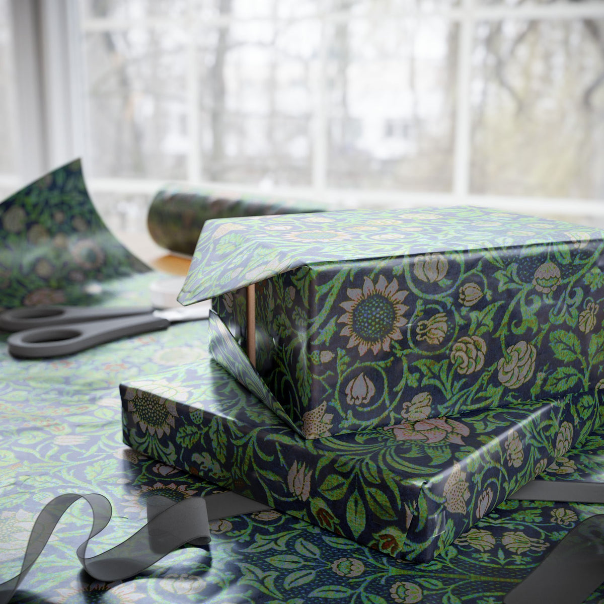 Gift box with floral pattern on a table with scissors and wrapping paper.