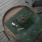 Green floral-patterned wrapping paper on a wooden tray with scissors and a spool of thread.