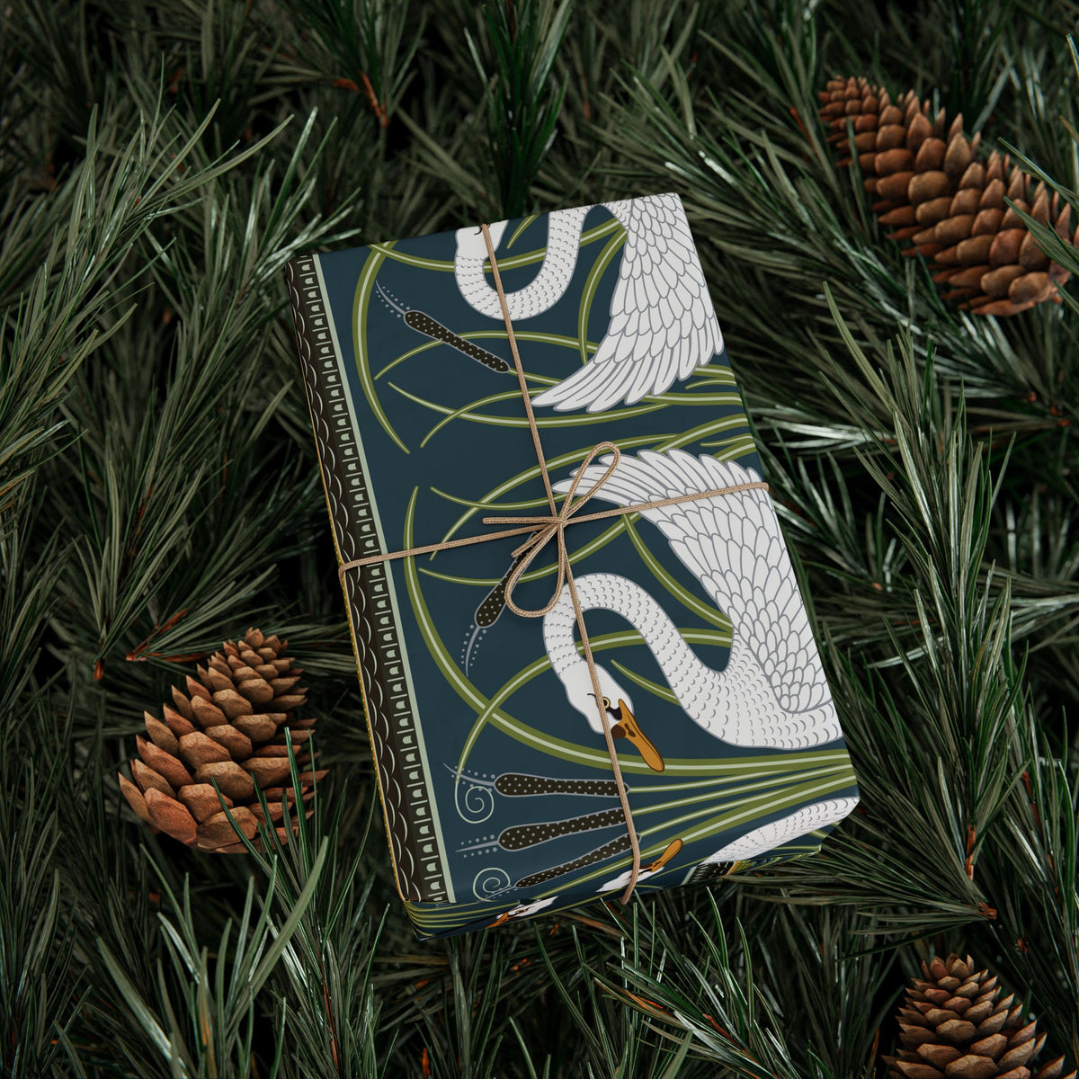 Wrapping paper with bird design tied with string on pine branches