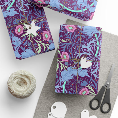 Gift-wrapped items with floral pattern, scissors, and yarn on a white surface