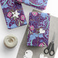 Gift-wrapped items with floral pattern, scissors, and yarn on a white surface