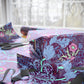Gift boxes wrapped in colorful floral-patterned paper with ribbons on a table.