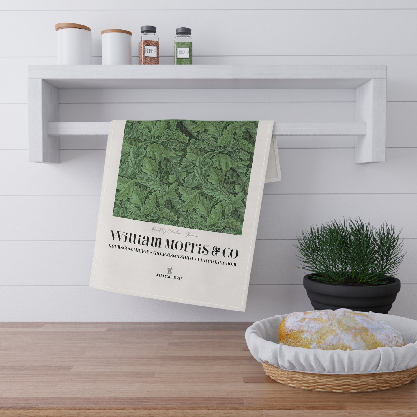 Green patterned towel hanging on a wooden shelf with a plant and basket in the foreground.