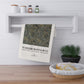 Decorative towel with William Morris & Co design hanging on a wall shelf with kitchen items below.
