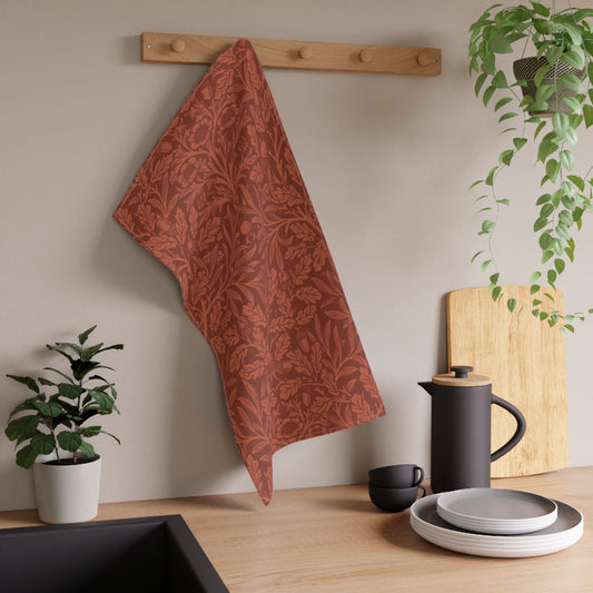 A kitchen tea towel with a floral and leaf William Morris & Co pattern, primarily in a brown and  colour.