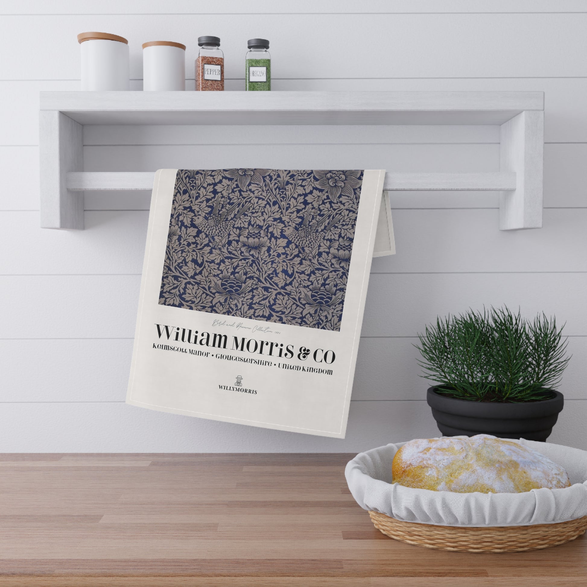 Decorative towel with 'William Morris & Co' branding hanging on a shelf in a kitchen setting.