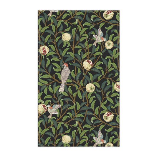 A kitchen tea towel with a design inspired by William Morris, featuring birds and pomegranate patterns on a dark background.
