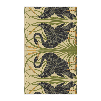 A kitchen tea towel with a repeating William Morris & Co pattern of black swans and green foliage on a beige background.
