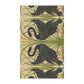 A kitchen tea towel with a repeating William Morris & Co pattern of black swans and green foliage on a beige background.