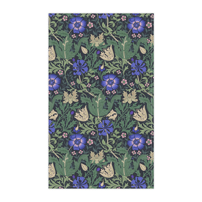 A kitchen tea towel with a floral William Morris & Co pattern featuring blue and green colours on a beige background.