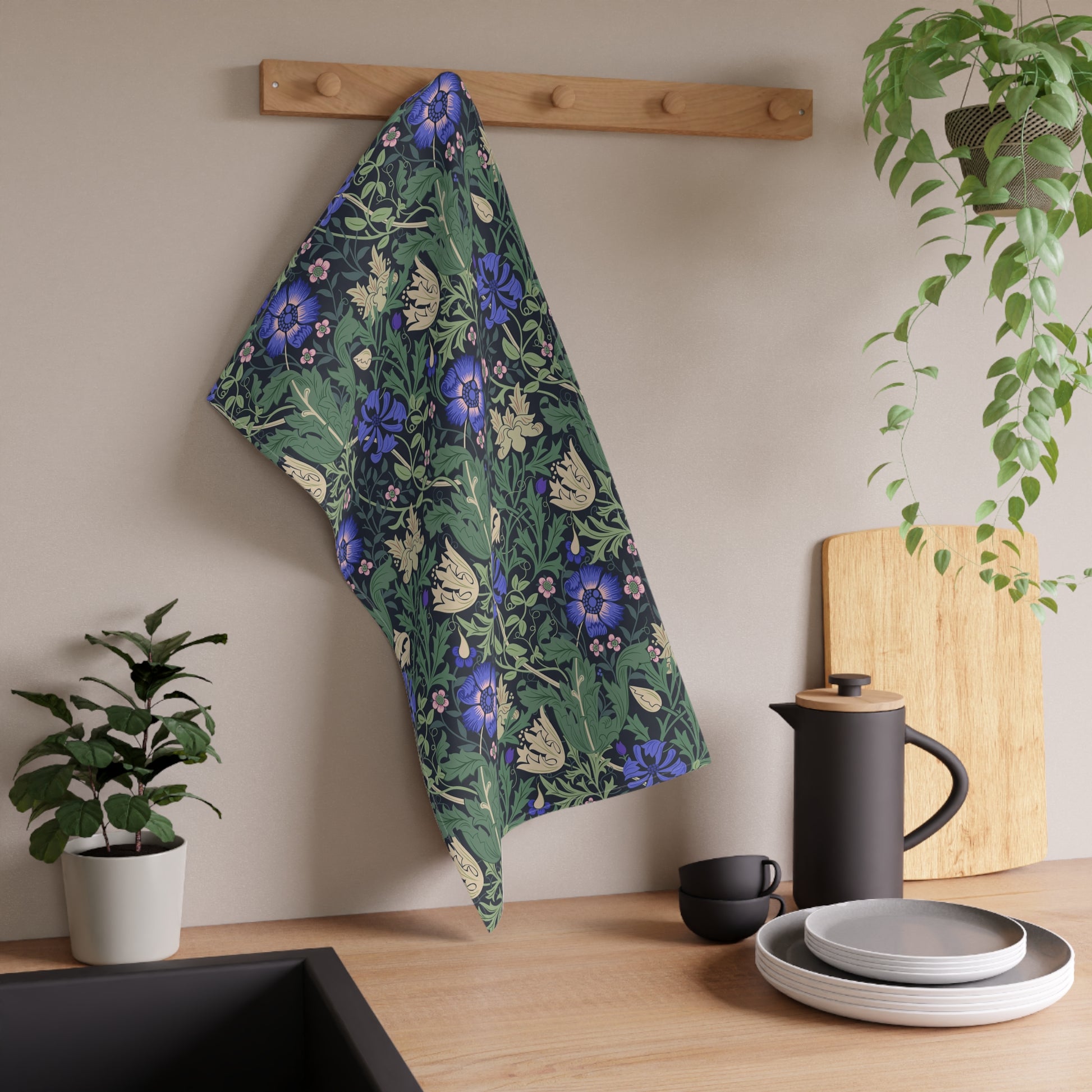 A kitchen tea towel with a floral William Morris & Co pattern featuring blue and green colours on a beige background.