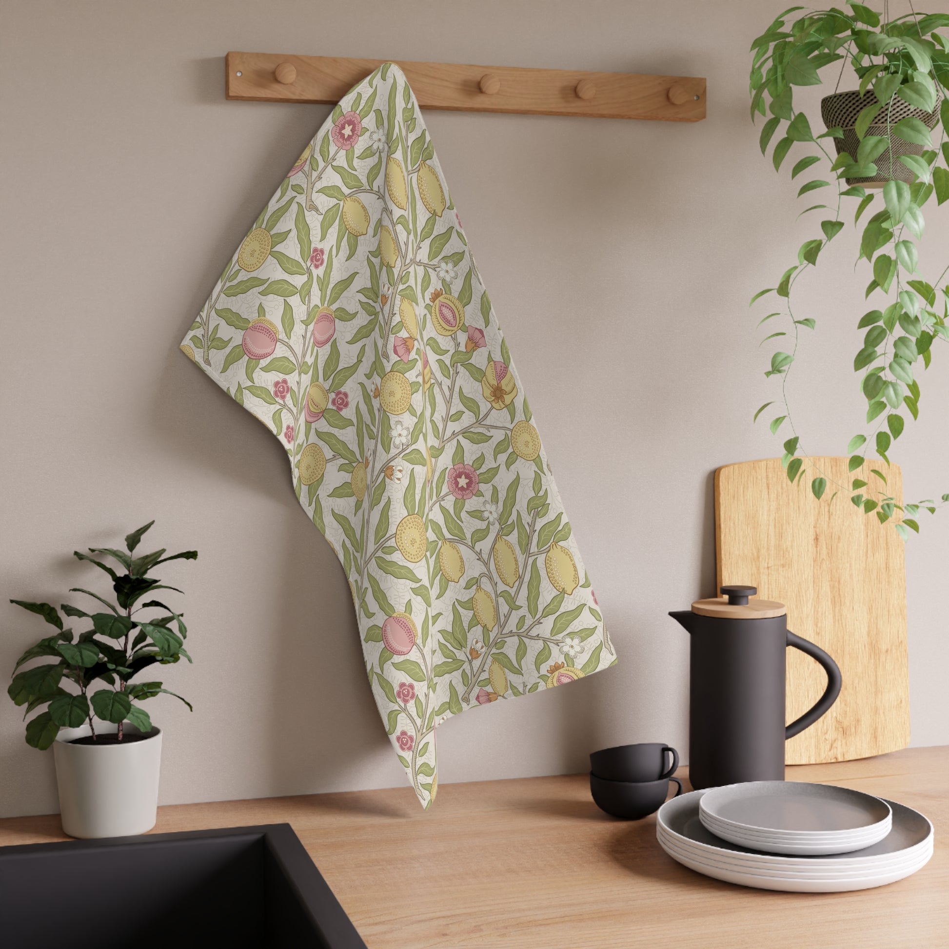 Floral towel hanging on a wooden rack with kitchen items and plants in the background