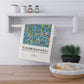 Decorative towel with floral pattern and 'William Morris & Co' branding hanging on a shelf.