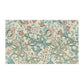 A rectangular decorative tea towel featuring a vintage botanical pattern with swirling blue-green vines, cream lilies, and muted pink flowers on a warm beige background.