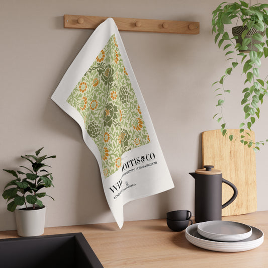 Floral towel hanging on a wooden rack with kitchen items and plants in the background
